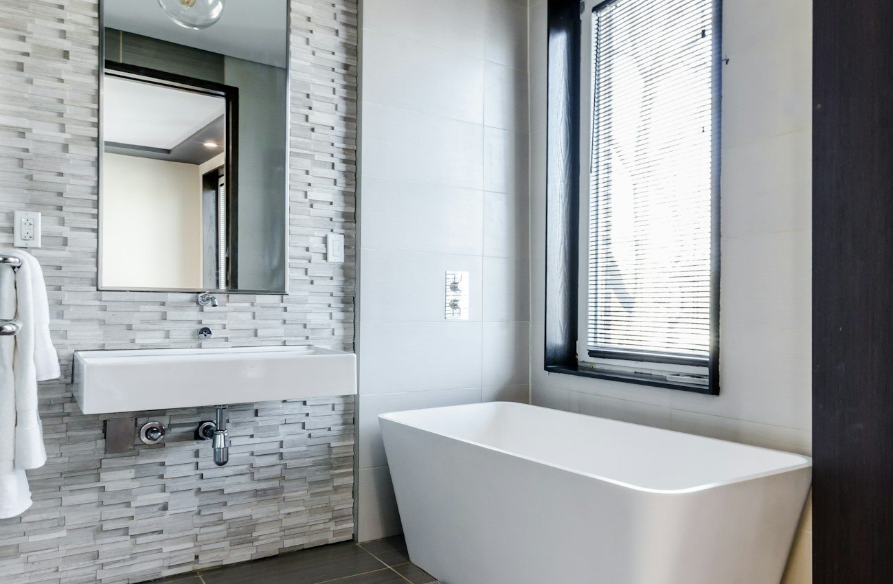 Elegant compact bathroom with a freestanding tub and natural light